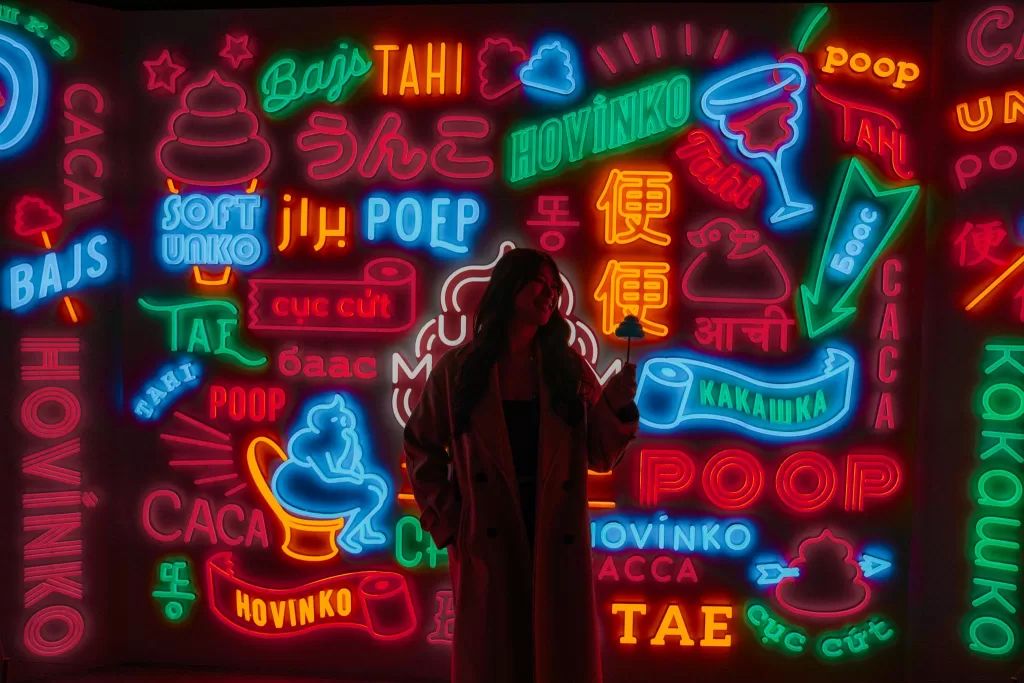 Angelia standing in front of neon signs at Unko Museum in Tokyo