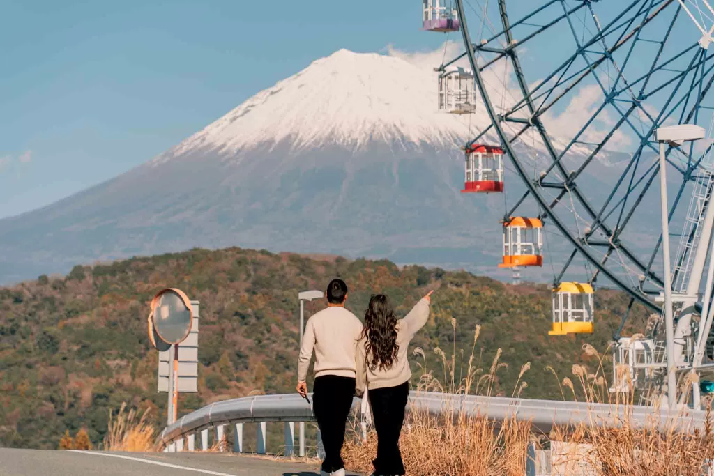 Angelia and Chris pointing at the Fuji Ferris Wheel in front of Mt. Fuji