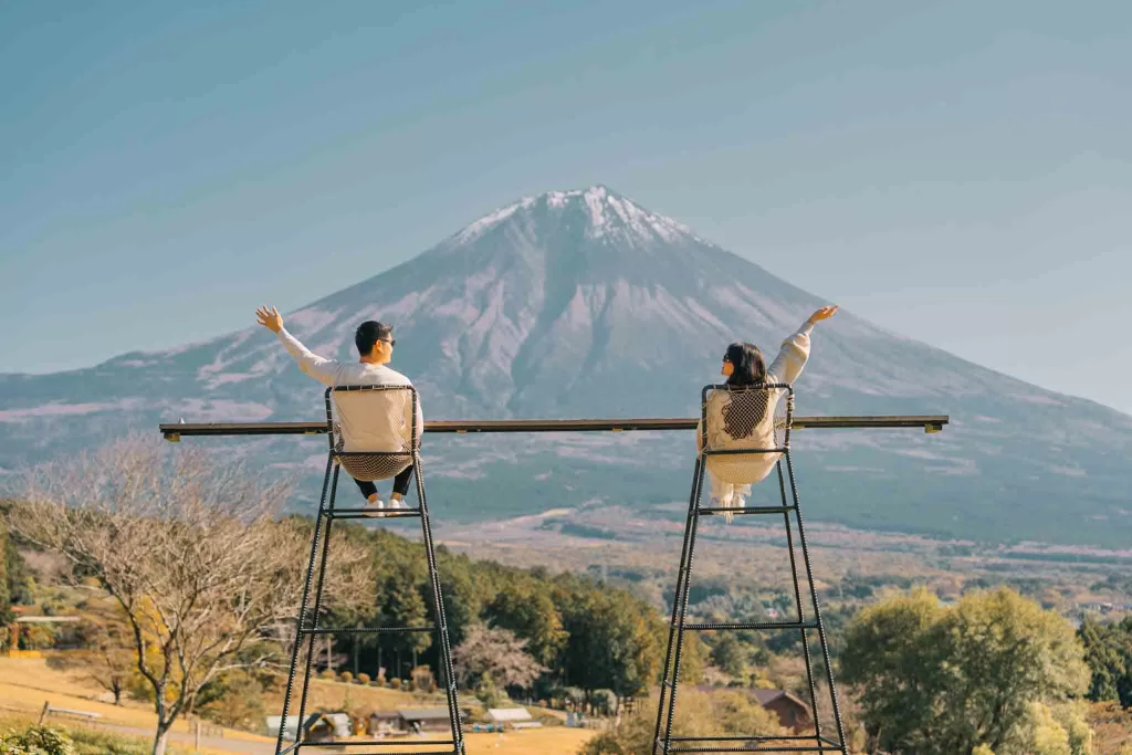 Angelia and Chris holding their arms out at Makaino Farms in front of Mt. Fuji