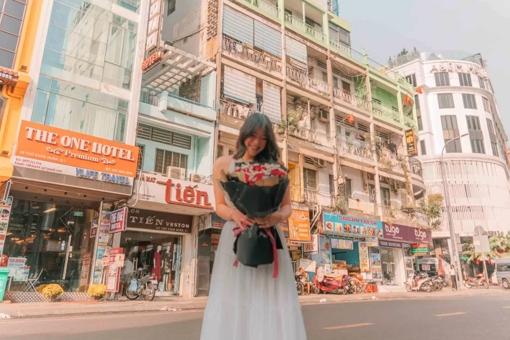 Angelia holding flowers near Ben Thanh Market in Ho Chi Minh