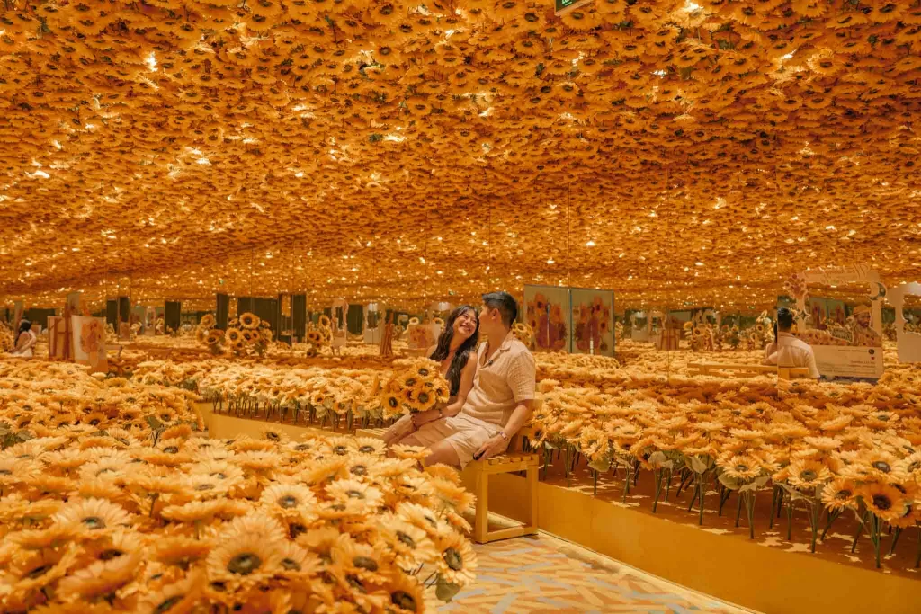 Angelia & Chris sitting on a bench while Angelia holds flowers at the Meta Show in Ho Chi Minh